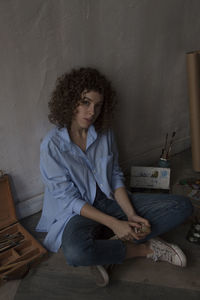 Young woman sitting on wall at home