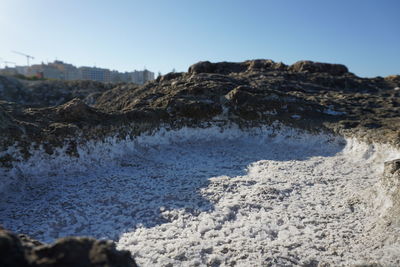 Rock formation on beach against clear sky