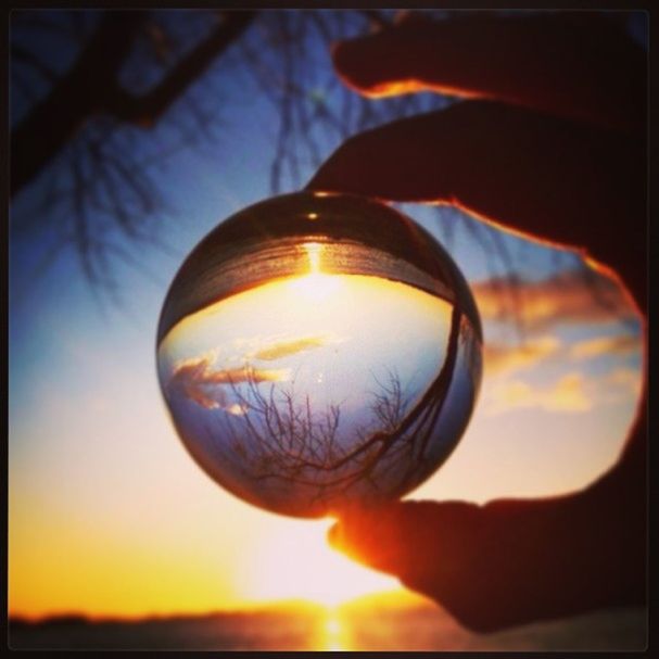 sphere, sunset, transfer print, close-up, focus on foreground, sky, auto post production filter, person, holding, circle, orange color, ball, silhouette, leisure activity, sun, reflection, outdoors