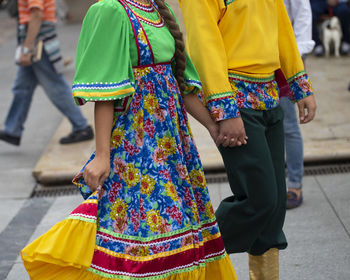 Midsection of man and woman walking on street