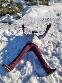 One person lying down face up in the snow