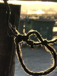 Close-up of chain hanging on rope against sky