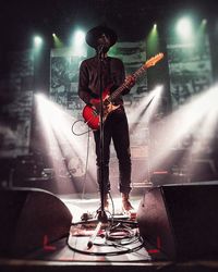 People playing guitar at music concert