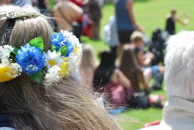 Close-up of woman wearing flowers in park