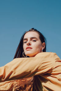 Portrait of young woman against blue sky