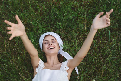 Portrait of young woman standing on grassy field