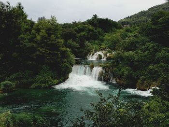 Scenic view of waterfall against sky