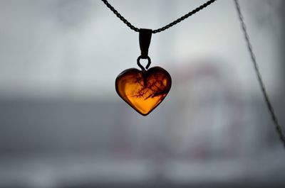 Close-up of heart shape pendant hanging on chain