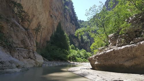 Scenic view of river by mountains against sky