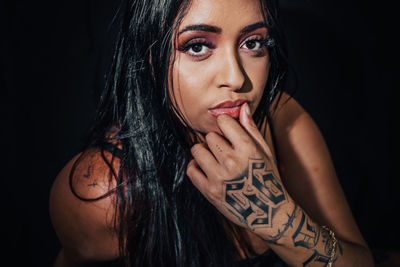 Portrait of beautiful woman against black background