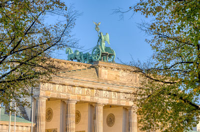 The backside of the famous brandenburg gate in berlin seen through some trees