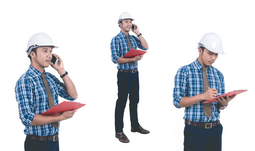 Young man using smart phone against white background