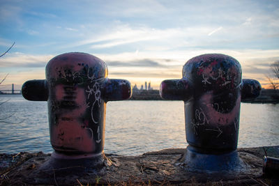 Two graffiti covered metal poles at graffiti pier with the philadelphia skyline behind them