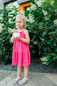 Portrait of cute girl standing on footpath