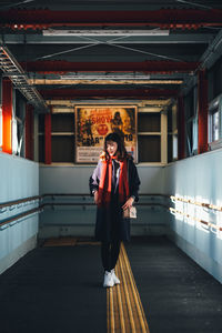 Portrait of young man standing on railing
