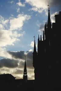 Silhouette of buildings against cloudy sky