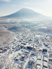 Aerial view of houses against sky during winter