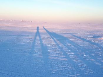 Shadow of person on snow covered land