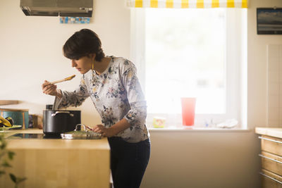 Youn woman cooking at home in a kitchen