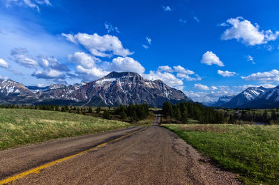 Road by mountains against sky