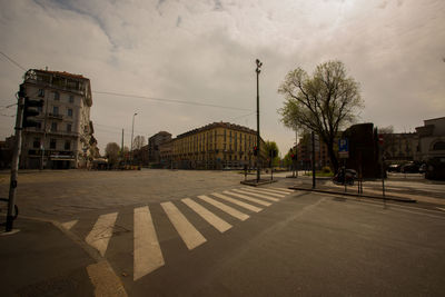 Road by buildings against sky