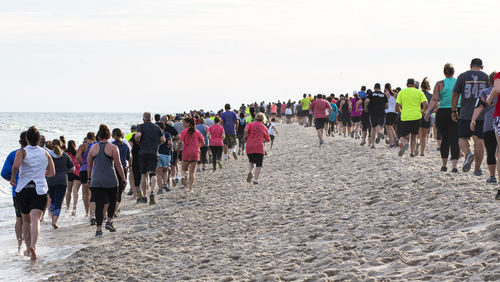 Rear view of people walking on beach