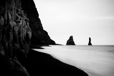 Scenic view of sea and cliff against clear sky