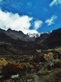 Scenic view of mountains against cloudy sky