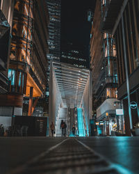 Surface level of street amidst buildings in city at night