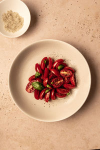 A plate of fresh cherry tomatoes with basil flatlay