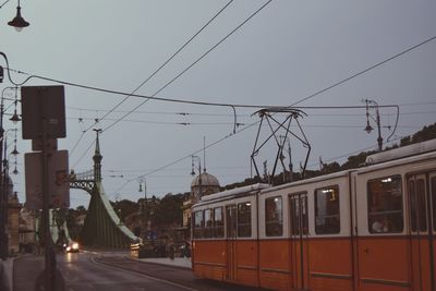 Train in city against sky during sunset