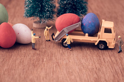 Close-up of easter eggs with figurines on wooden table