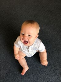 High angle view of cute baby boy laughing at home