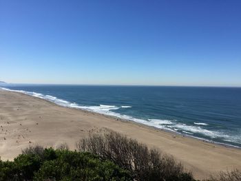 Scenic view of sea against clear blue sky