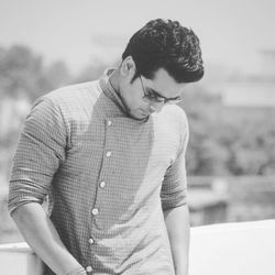 Handsome young man standing outdoors during sunny day