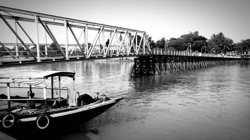 Boats moored on river against clear sky