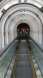 High angle view of woman standing on escalator