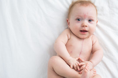 Portrait of cute baby boy lying on bed