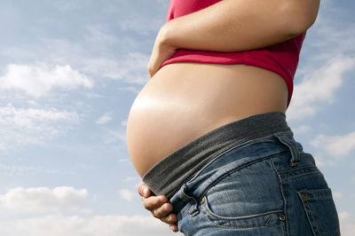 Midsection of woman standing against sky