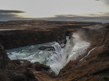 Scenic view of waterfall against sky