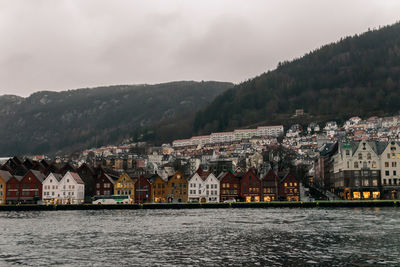Townscape by river against sky in town