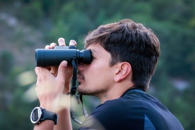 A man observes animals in nature with binoculars. birdwatching
