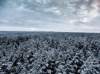 Scenic view of snow covered land against sky