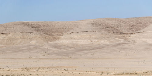 Sand dunes in desert against clear sky