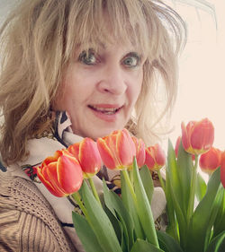 Close-up portrait of woman holding tulips