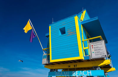 Low angle view of yellow birds against blue sky