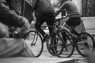 Low section of men sitting on bicycle