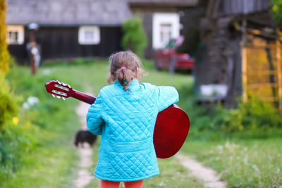 Cute girl playing guitar outdoors