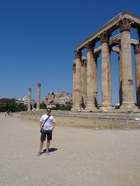 Rear view of man standing in front of historical building