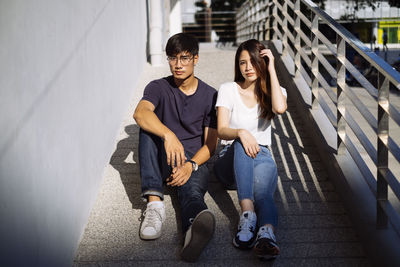 Portrait of young couple sitting on staircase